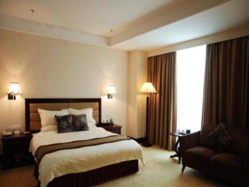 Pokój hotelowy z dużym łóżkiem i krzesłem w obiekcie Cheerful Hotel w mieście Nanhai