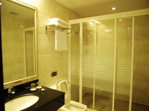 W łazience znajduje się prysznic, umywalka i toaleta. w obiekcie Cheerful Hotel w mieście Nanhai