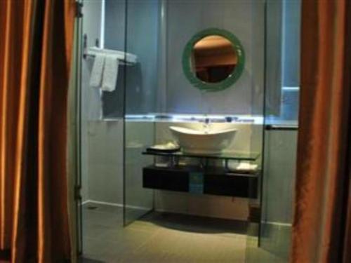 y baño con lavabo y ducha acristalada. en Guangna Hotel en Huizhou