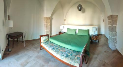 Casa Alta في لاكويلا: غرفة نوم بسرير اخضر وطاولة
