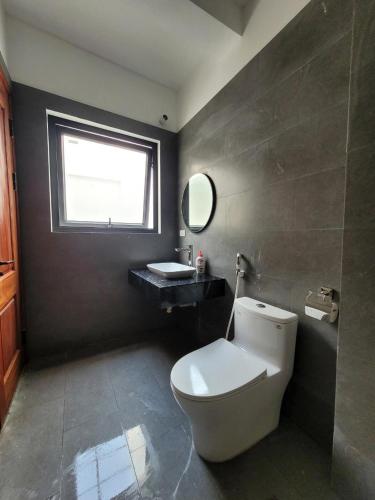a bathroom with a white toilet and a sink at Noi Bai Flight Path Homestay in Hanoi