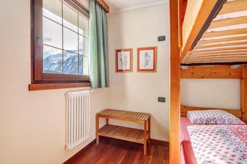 ein Schlafzimmer mit einem Etagenbett und einer Leiter in der Unterkunft Residence Larice Bianco App n2 in Campodolcino
