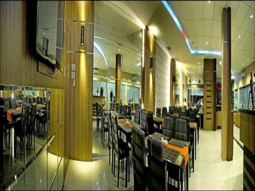Benteng Hotel Pekanbaru في Parit: غرفة طعام مع طاولات وكراسي في مبنى