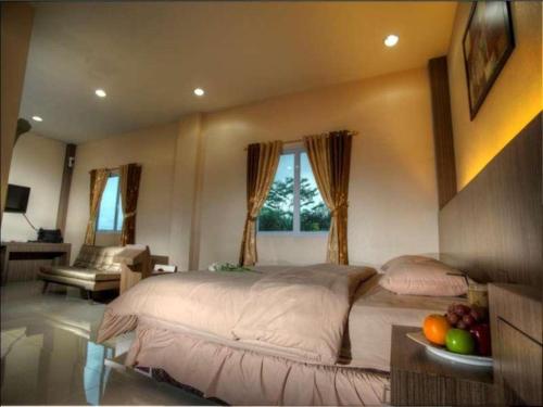 Benteng Hotel Pekanbaru في Parit: غرفة نوم مع سرير كبير مع وعاء من الفواكه