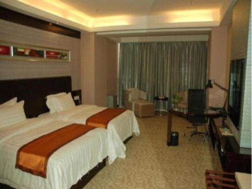 a hotel room with a bed and a flat screen tv at Aksu Pudong Holiday Hotel in Aksu