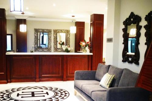a living room with a couch and a mirror at Island Hotel Durban in Durban