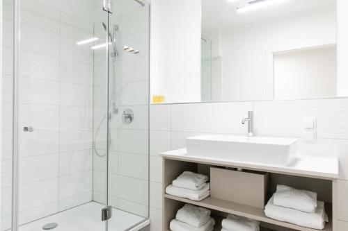 y baño blanco con lavabo y ducha. en MyApartments Vienna Rooftop, en Viena