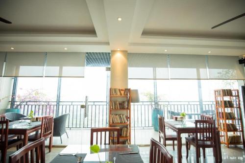 Gia Bao Hotel Bac Ninh في Ða Hội: غرفة طعام مع طاولات وكراسي ونوافذ