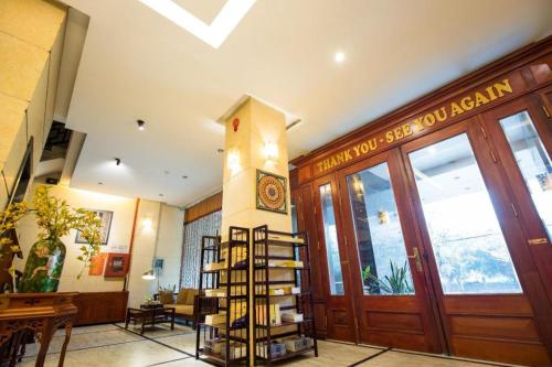 a library with a clock on the wall and a wooden door at Gia Bao Hotel Bac Ninh in Hanoi