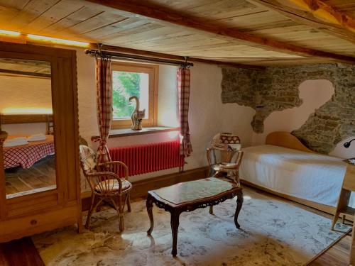 a bedroom with a bed and a table and chairs at Chalet del Lago in Ceresole Reale