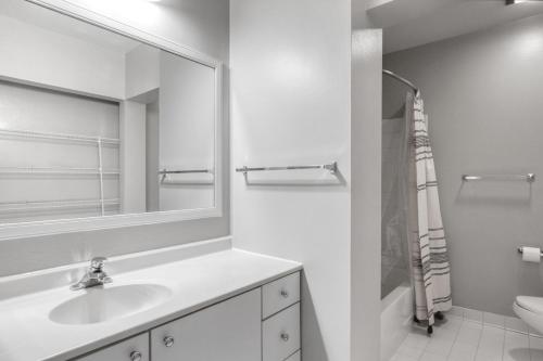 a white bathroom with a sink and a mirror at Loop 2br w gym doorman nr L CHI-813 in Chicago