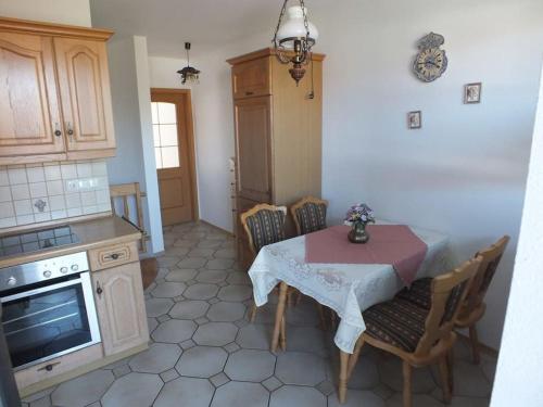 a kitchen with a table and some chairs and a stove at Ferienwohnung Jersemann in Steingaden