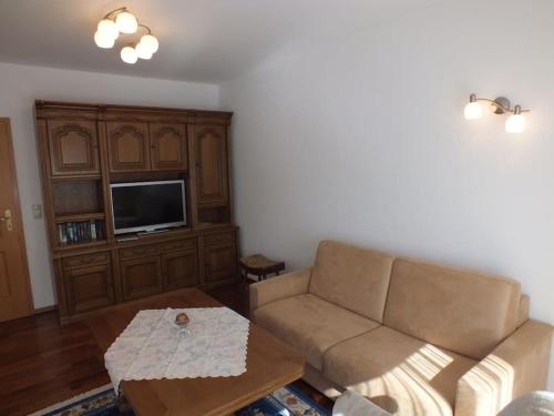 a living room with a couch and a tv at Ferienwohnung Jersemann in Steingaden