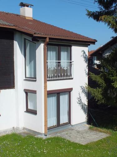 a white house with a balcony on the side of it at Ferienwohnung Jersemann in Steingaden