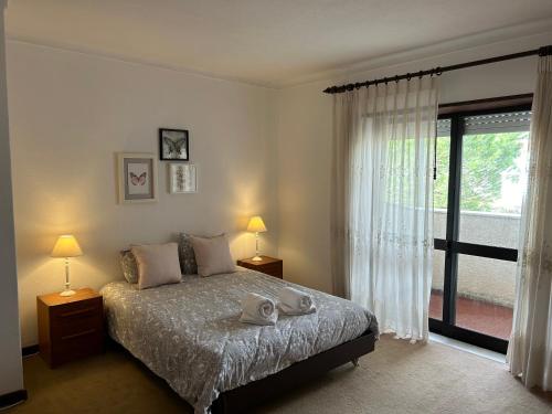 a bedroom with a bed and a large window at Casa São José in Carritos