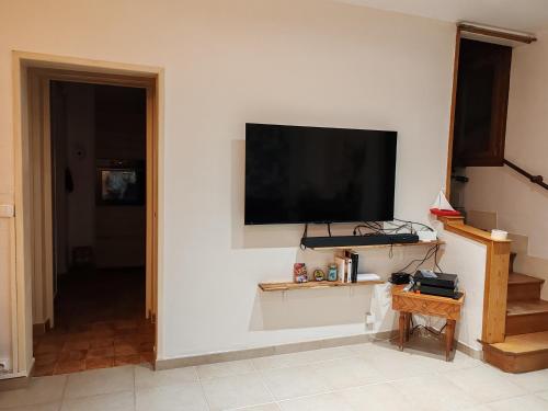 a living room with a flat screen tv on a wall at Villa Francette à 500m de la plage in Ouistreham