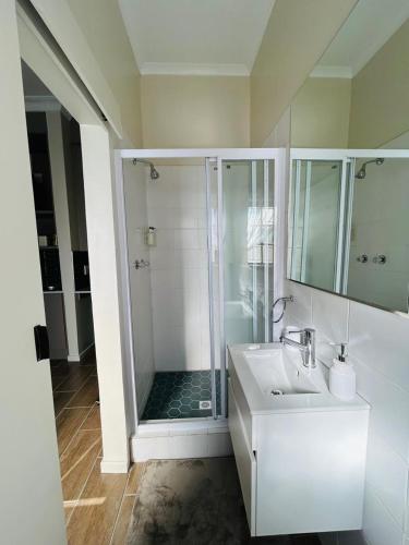 a white bathroom with a shower and a sink at Panorama Self Catering 2 in Panorama