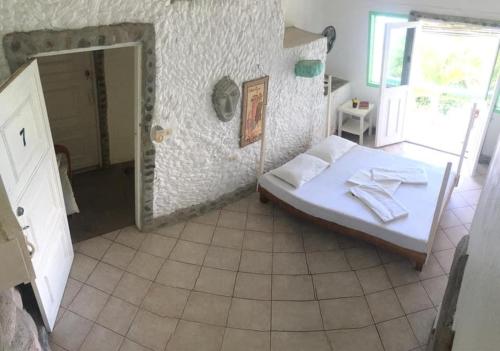 Liberty's Community Lodge and Diving في دوماغيتي: غرفة نوم صغيرة مع سرير ومرآة
