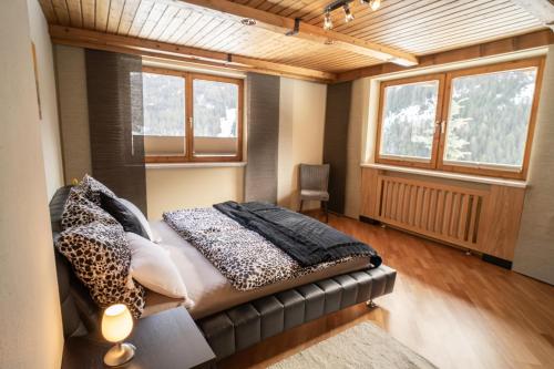 a bedroom with a bed in a room with windows at Ferienwohnung Alpenblick in Navis