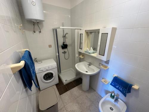 ein weißes Badezimmer mit einem Waschbecken und einer Waschmaschine in der Unterkunft Appartamenti Rivabella Gallipoli in Rivabella