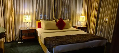 a hotel room with a bed with two tables and two lamps at Raymond Apartment Times Square kuala Lumpur in Kuala Lumpur