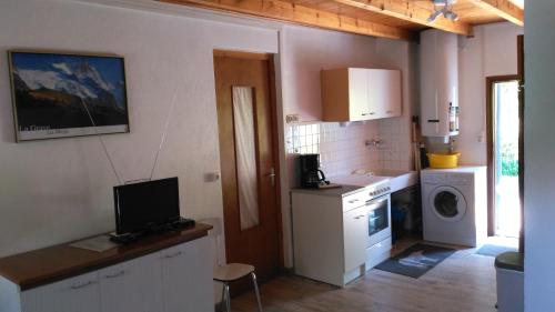 une cuisine avec une cuisinière, un évier et un micro-ondes dans l'établissement Les quatre marmottes, à Villar-dʼArêne