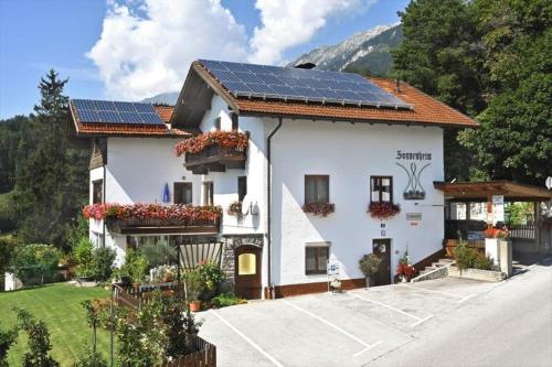 ein Haus mit Sonnenkollektoren auf dem Dach in der Unterkunft Gästehaus Sonnenheim in Thaur