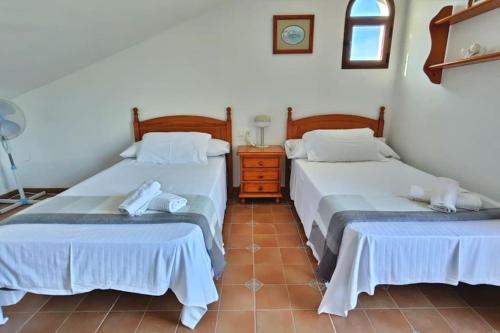 two beds sitting next to each other in a room at Casa Sueño Español in Torrox