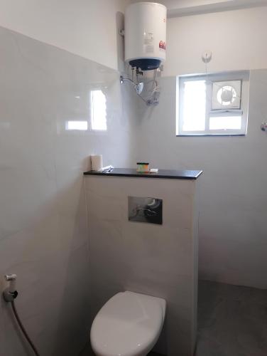 a bathroom with a white toilet and a window at Embassy Suites in Hyderabad