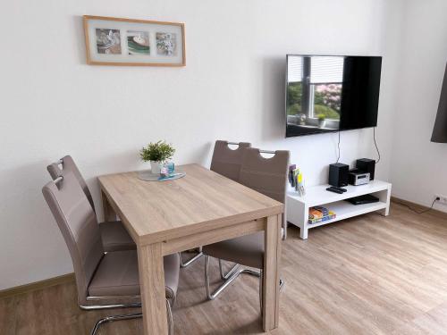 a dining room with a wooden table and chairs at Appartementhaus Nige Ooge Wohnung Nr 1 in Sahlenburg