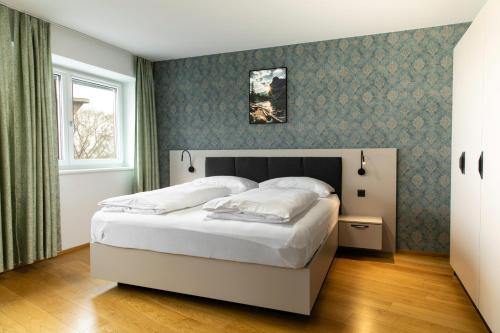 una camera da letto con un grande letto bianco e una finestra di MyApartments Vienna Rooftop a Vienna