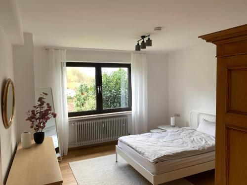 una camera bianca con un letto e una finestra di Appartement Abendsonne a Rotenburg an der Fulda