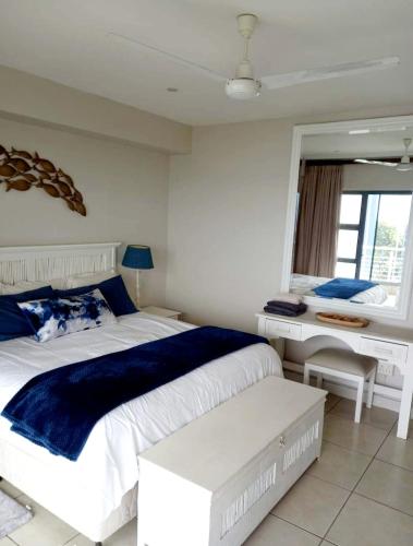 um quarto com uma grande cama branca e uma secretária em Indigo Bay 29 em Margate