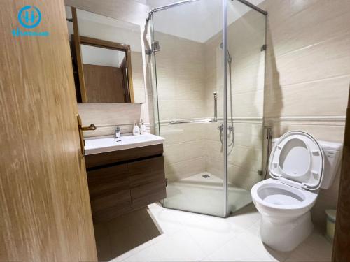 a bathroom with a shower and a toilet and a sink at Happerland HomeStay Căn hộ Khách sạn 2 phòng Cao cấp Long Xuyên in Long Xuyên