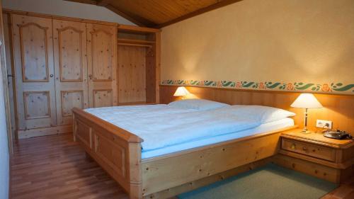 um quarto com uma cama grande e uma mesa de cabeceira com um candeeiro em Gästehaus Nocker em Seefeld no Tirol
