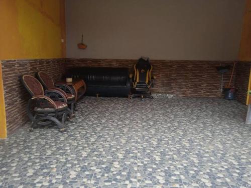 a room with chairs and a couch and a brick wall at Agus Homestay in Cibeunjing