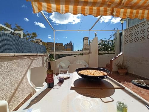 una mesa con un tazón de comida y una botella de vino en Casa Alkabir Campello, en El Campello