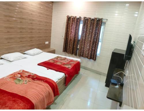 een hotelkamer met 2 bedden en een televisie bij Hotel prince palace & restaurant , Ajmer in Ajmer