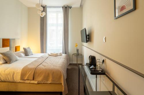 um quarto com uma cama e uma televisão na parede em Expo Apartments em Poznań