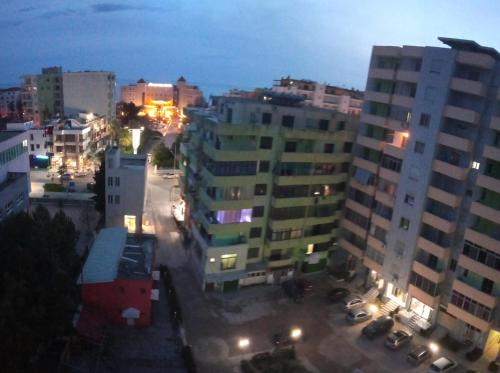 uitzicht op een stad in de nacht met gebouwen bij AMEL Familiar HOUSE in Durrës