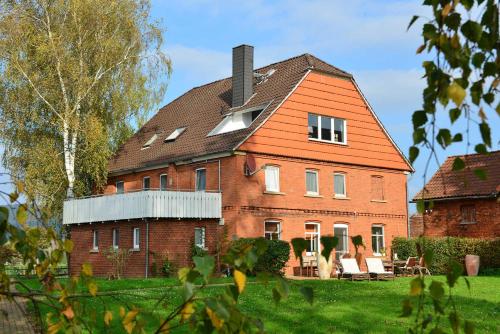 een groot bakstenen huis met een oranje dak bij Weserlounge Apartments in Hessisch Oldendorf