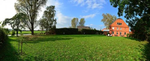 un gran campo de césped junto a una gran casa de ladrillo en Weserlounge Apartments en Hessisch Oldendorf