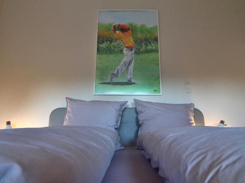 2 camas en una habitación con una foto de un jugador de béisbol en Appartement Crows Nest en Ankum
