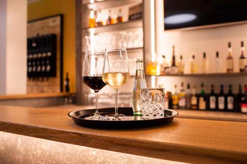 a tray with two glasses of wine on a bar at Herrenhaus im Artland in Ankum