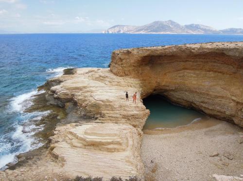 two people standing on a cliff near the ocean at Villa St' Astra in Koufonisia