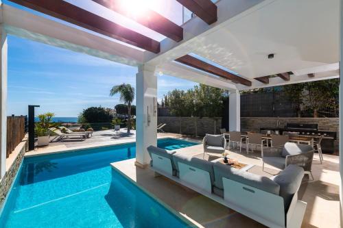 an outdoor patio with a swimming pool and a pergola at Amazing villa in Green Hill Marbella in Mijas