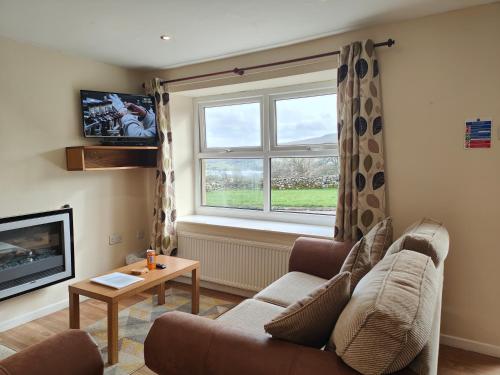 ein Wohnzimmer mit einem Sofa und einem Fenster in der Unterkunft Holiday Cottage 4 in Penrith
