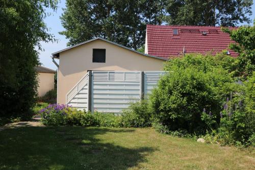 una casa con una valla delante de un patio en Ferienwohnungen Polchow - direkt am Wasser, en Polchow