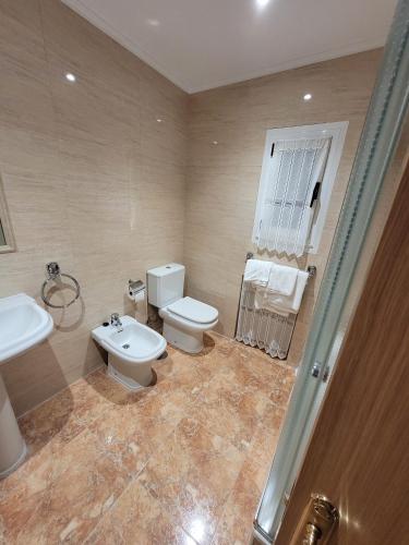 a bathroom with a toilet and a sink at Hostal San Felix in Gijón