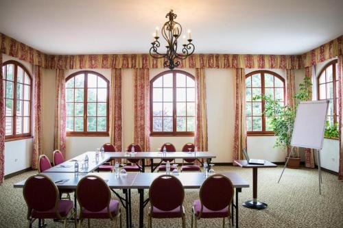 a conference room with tables and chairs and windows at Bodrogi Kúria Wellness Hotel in Inárcs